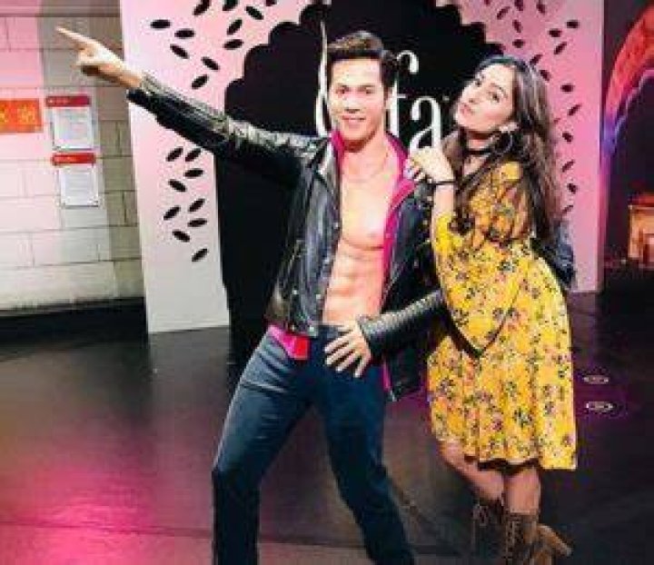 Dinky Kapoor posing alongside the wax statue of Varun Dhawan